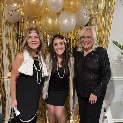 Three people celebrating together at a Quinn & Wilson event